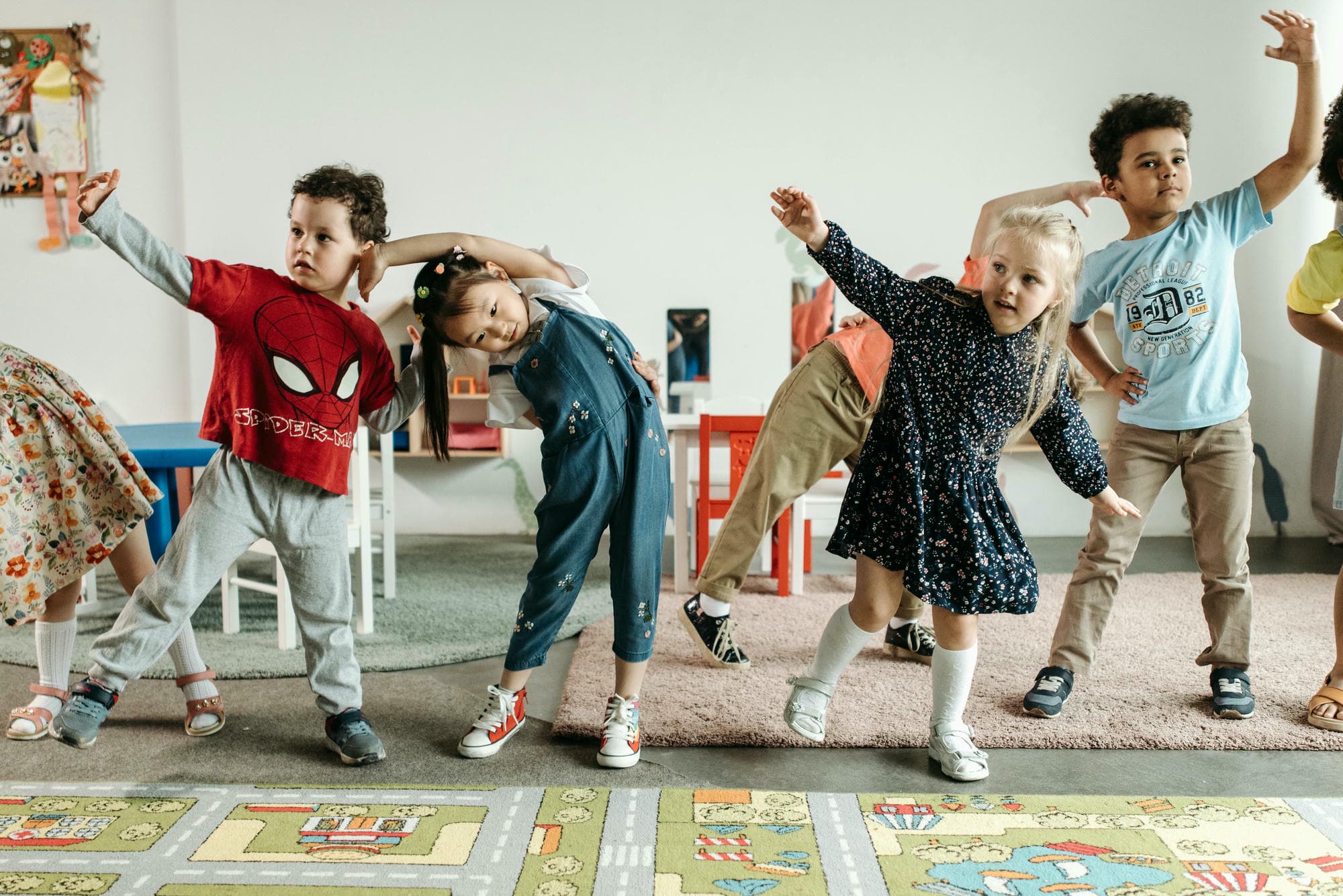 A group of children dancing in the playroom, wearing cute and pants with leg warmers.